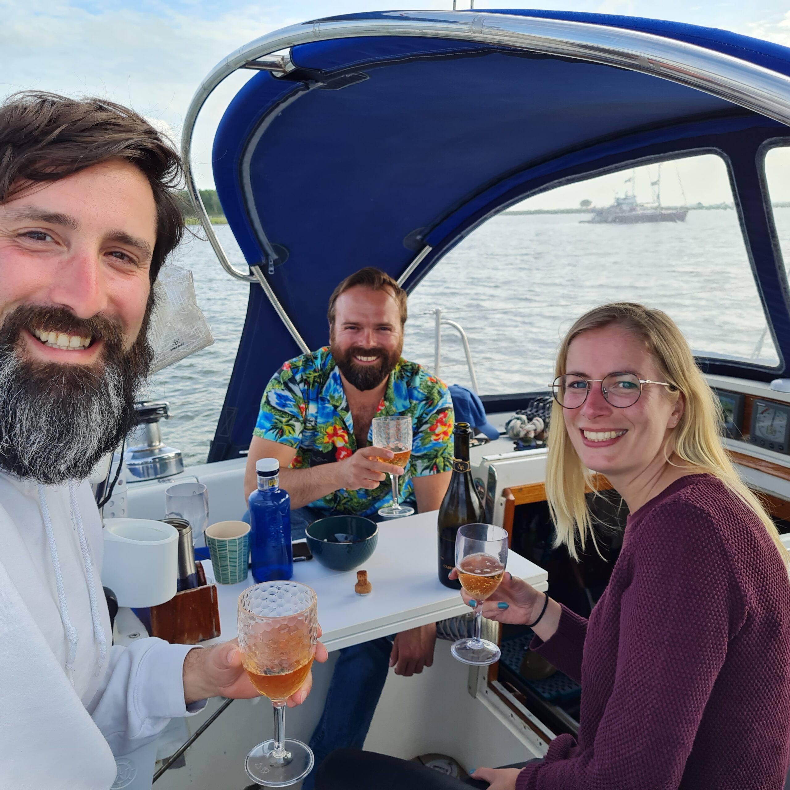 Joyful group of friends enjoying a toast on a sailboat at Markermeer during golden hour